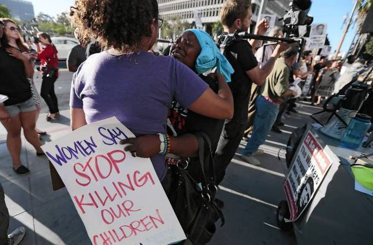 Peta Lindsey, left, embraces a weeping Rajeeyah Bilal-Varney after delivering an emotional speech at a rally on the steps of L.A. City Hall. Varney’s 17-year-old son was killed in the 1990s.