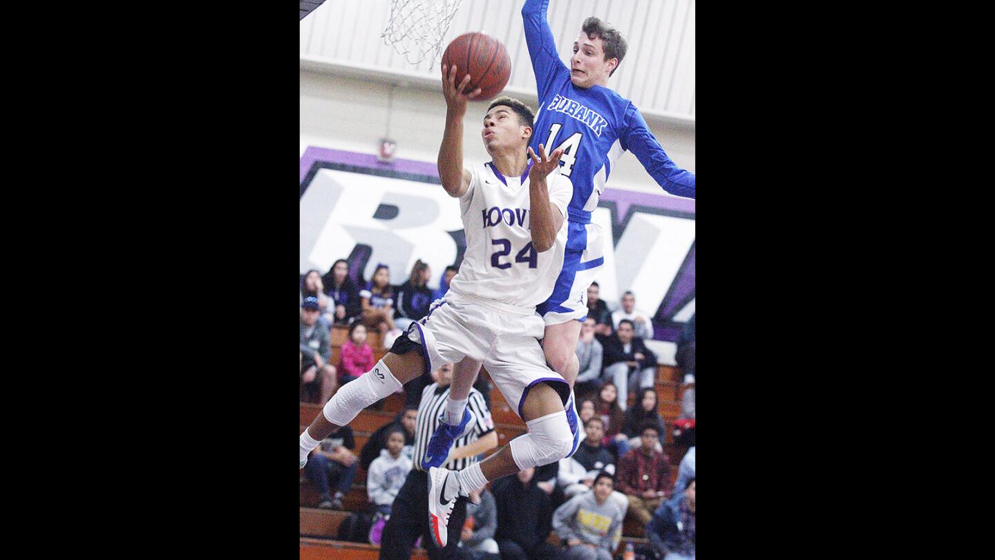 Hoover's Larenz Garcia-Joseph hangs in the air attempting a reverse layup as Burbank's Cole Barton fouls him during the shot in a Pacific League boys' basketball game at Hoover High School in Glendale on Monday, Feb. 1, 2016. Hoover won the game 52-50.