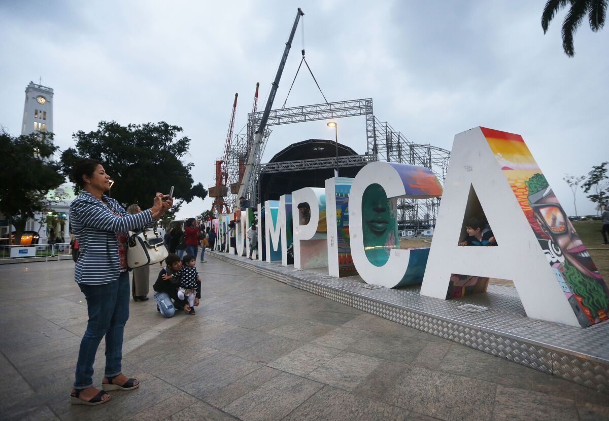 People gather and take photos Wednesday at the Cidade Olimpica sign in the Port District of Rio de Janeiro.