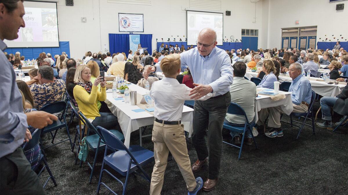Rusty Lamboley gives his grandson Lio Balossi a hug after Lio gave a speech about him during an oral history luncheon at Thurston Middle School in Laguna Beach.