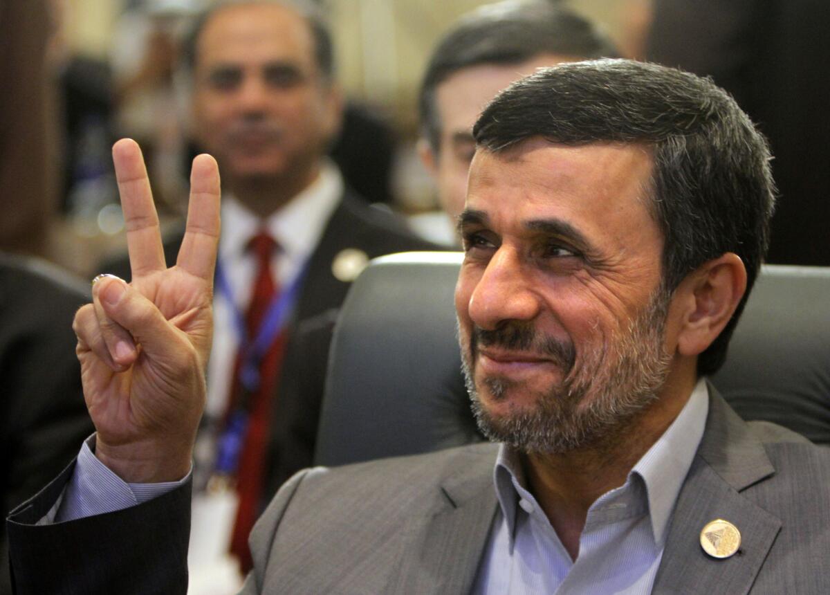 Iranian President Mahmoud Ahmadinejad flashes the victory sign as he attends the 12th summit of the Organization of Islamic Cooperation in Cairo on Wednesday. Saeed Mortazavi, a key ally, was said to be released from custody Wednesday in Iran after being jailed on what were reportedly corruption charges.