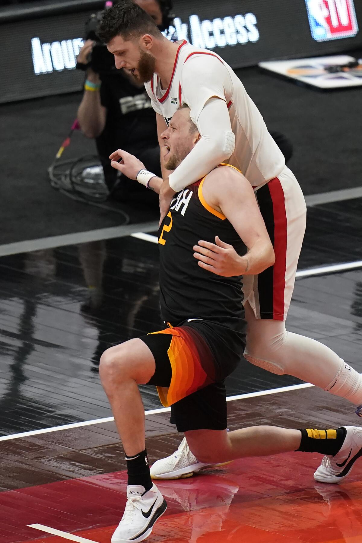 Portland Trail Blazers center Jusuf Nurkic, top, fouls Utah Jazz guard Joe Ingles during the second half of an NBA basketball game Wednesday, May 12, 2021, in Salt Lake City. (AP Photo/Rick Bowmer)