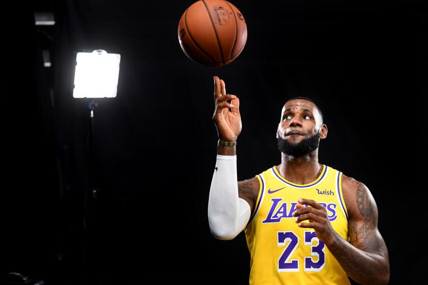 LeBron James poses for a photo while spinning a basketball on his finger during media day at the Lakers' training facility in El Segundo.