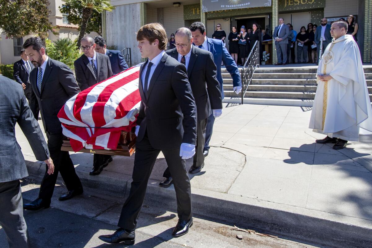 Pallbearers carry Ernest Z. Robles' casket.