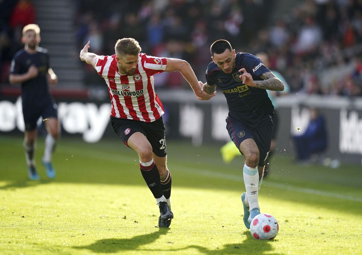 Brentford's Kristoffer Ajer, left, and Burnley's Dwight McNeil battle for the ball during the English Premier League soccer match between Brentford and Burnley at Brentford Community Stadium, London, Saturday March 12, 2022. (John Walton/PA via AP)