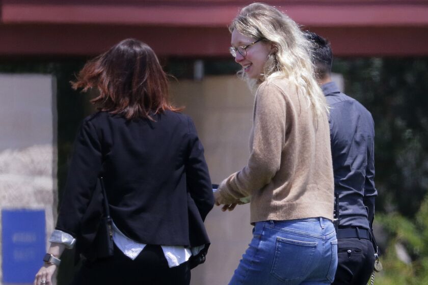 Disgraced Theranos CEO Elizabeth Holmes, center, is escorted by prison officials into a federal women’s prison camp on Tuesday, May 30, 2023, in Bryan, Texas. Holmes will spend the next 11 years serving her sentence for overseeing an infamous blood-testing hoax. (AP Photo/Michael Wyke)
