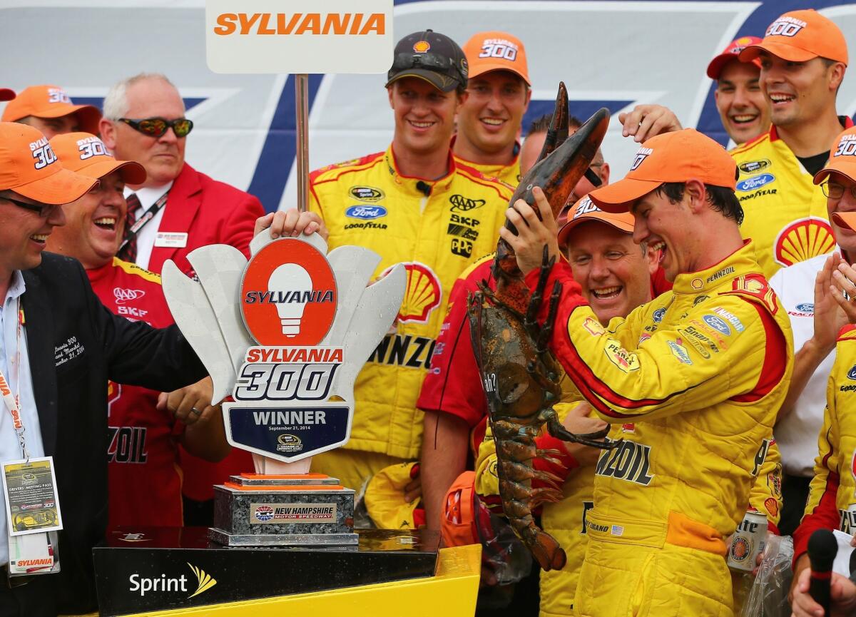 Joey Logano receives a lobster in victory lane after winning the Sylvania 300 on Sunday at New Hampshire Motor Speedway.