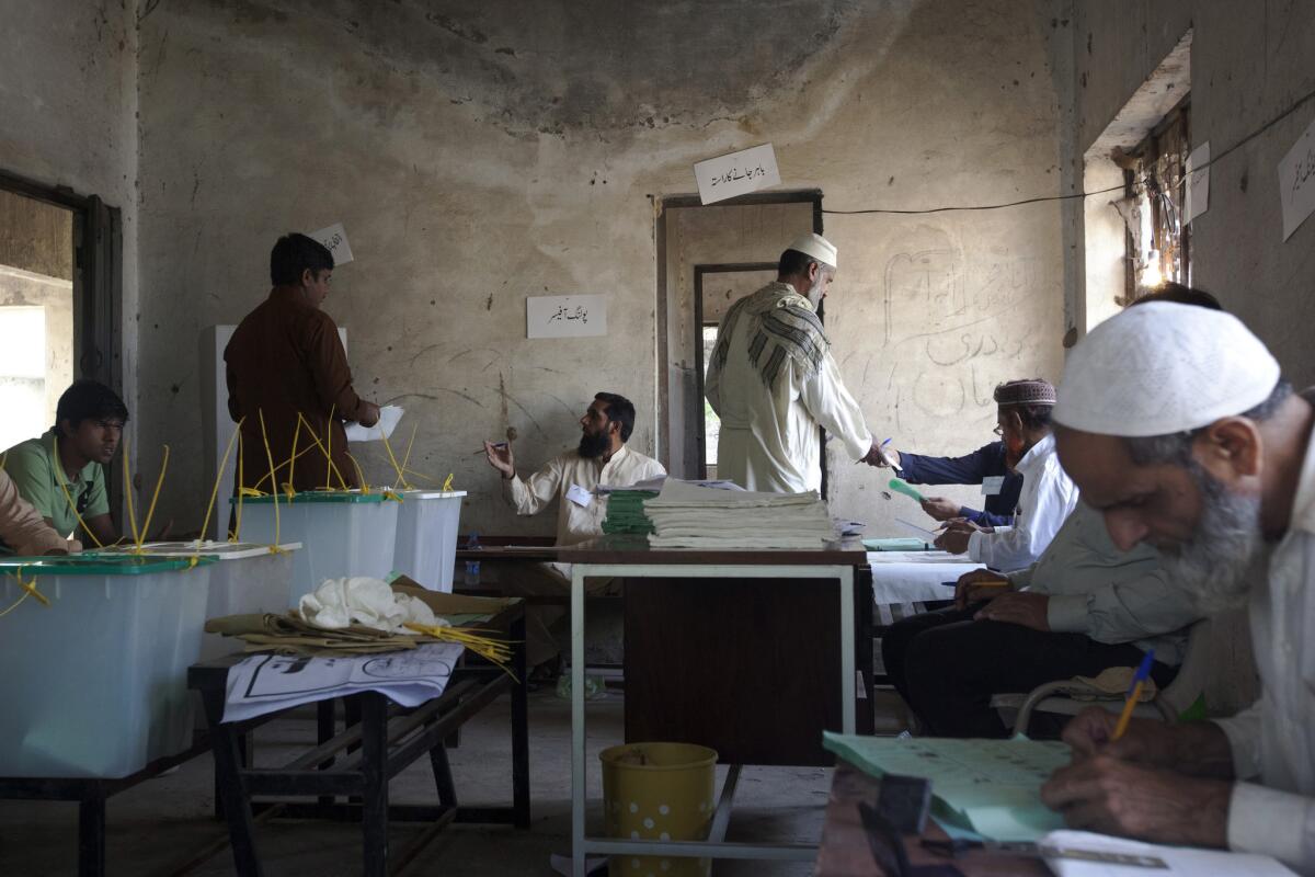 Voters receive their ballot papers at a polling station in Lahore, Pakistan.