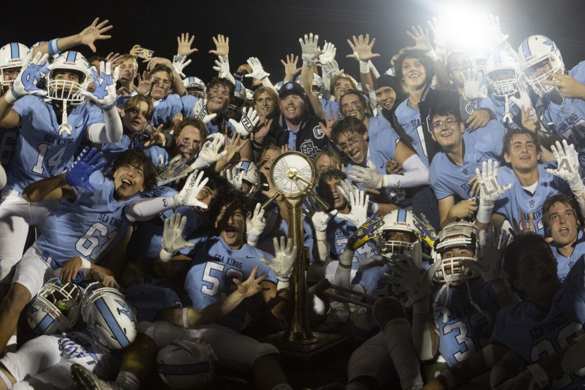 Corona del Mar celebrates after defeating Newport Harbor in Friday night's Battle of the Bay game at Davidson Field.