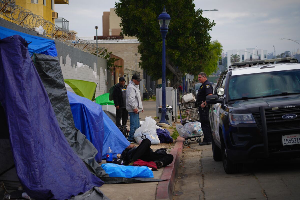Near the corner of Imperial Avenue in East Village, San Diego police officers clear area of encampments