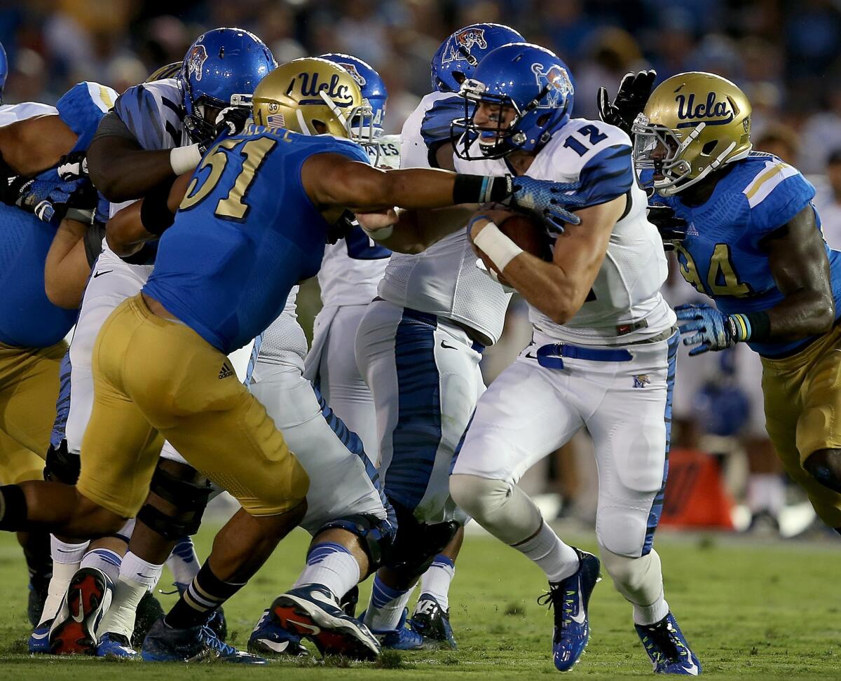 UCLA linebacker Aaron Wallace pressures Memphis quarterback Paxton Lynch in the first quarter.