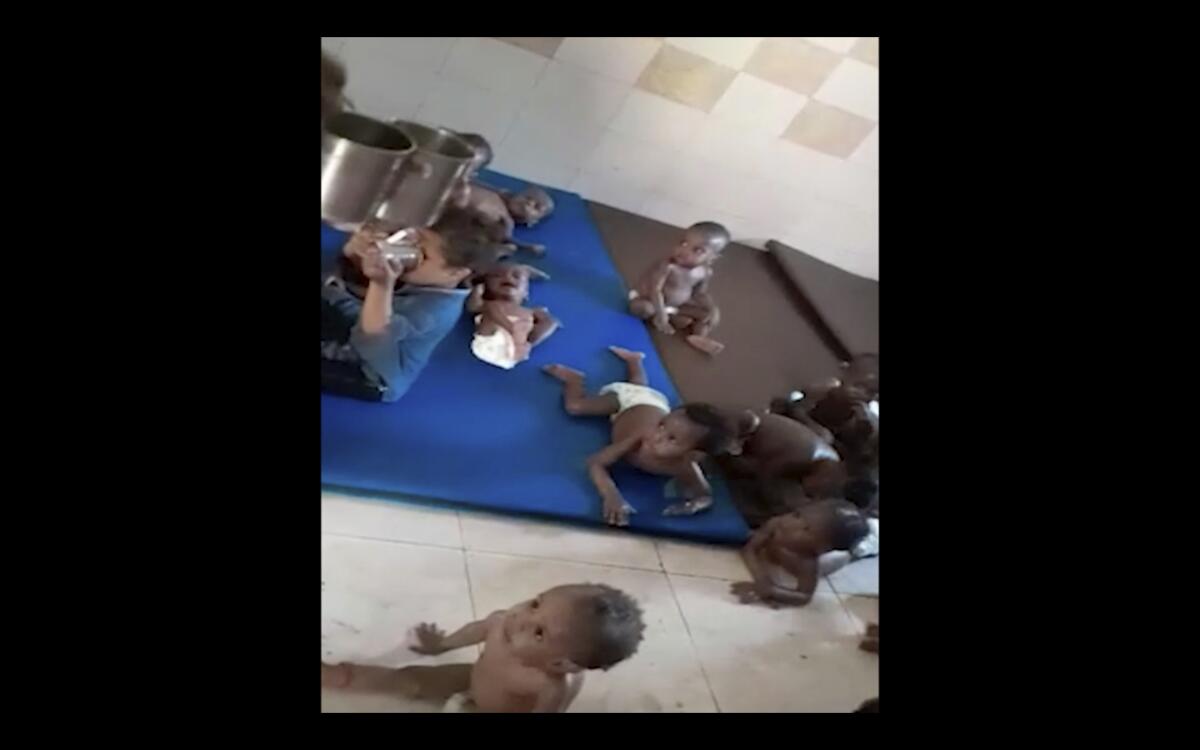 Small children in diapers on mats on a floor