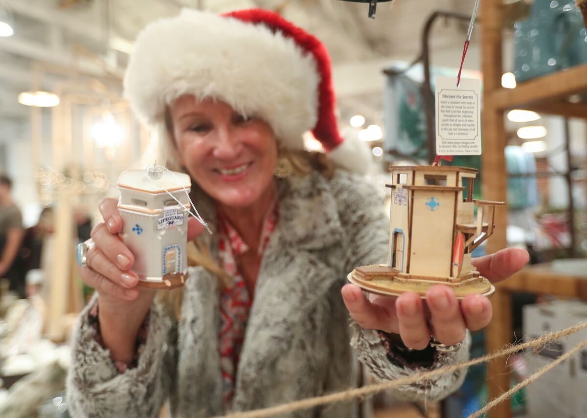 Resident Cathy Conroy tries to pick between two lifeguard tower Christmas ornaments during Hospitality Night on Friday.
