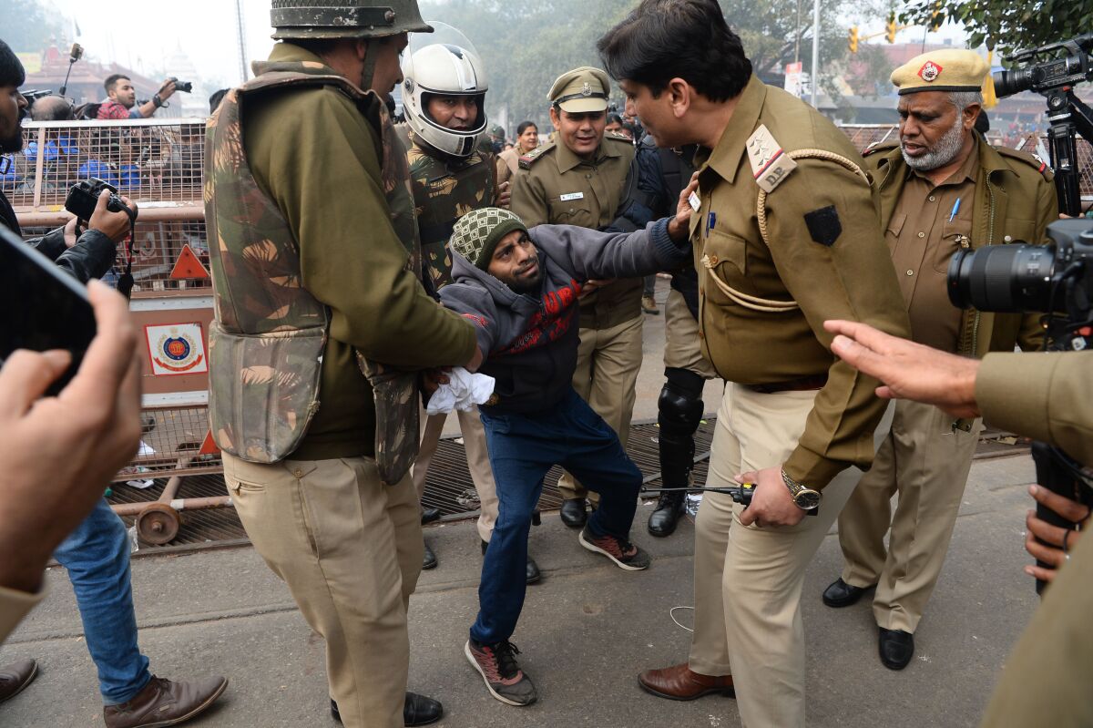 Police detain a man during a protest in New Delhi against India's new citizenship law.