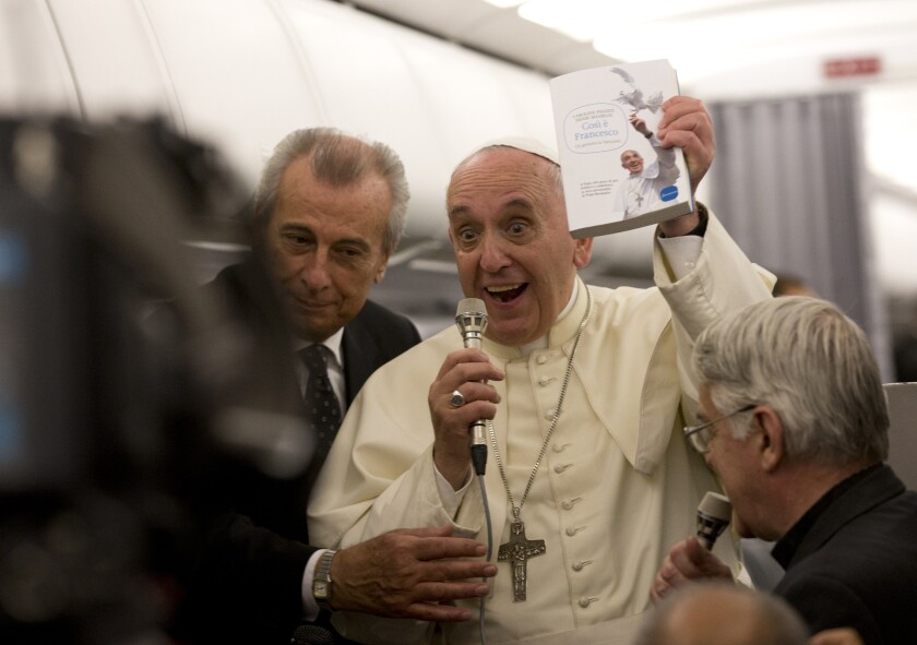 Pope Francis talks with reporters on the airplane on his way back to Rome from Albania on Sept. 21.