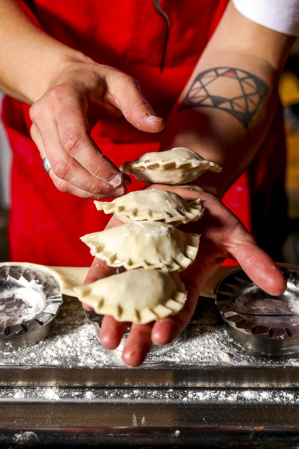 A woman prepares pierogi with a buckwheat, dried apple and tomato filling.