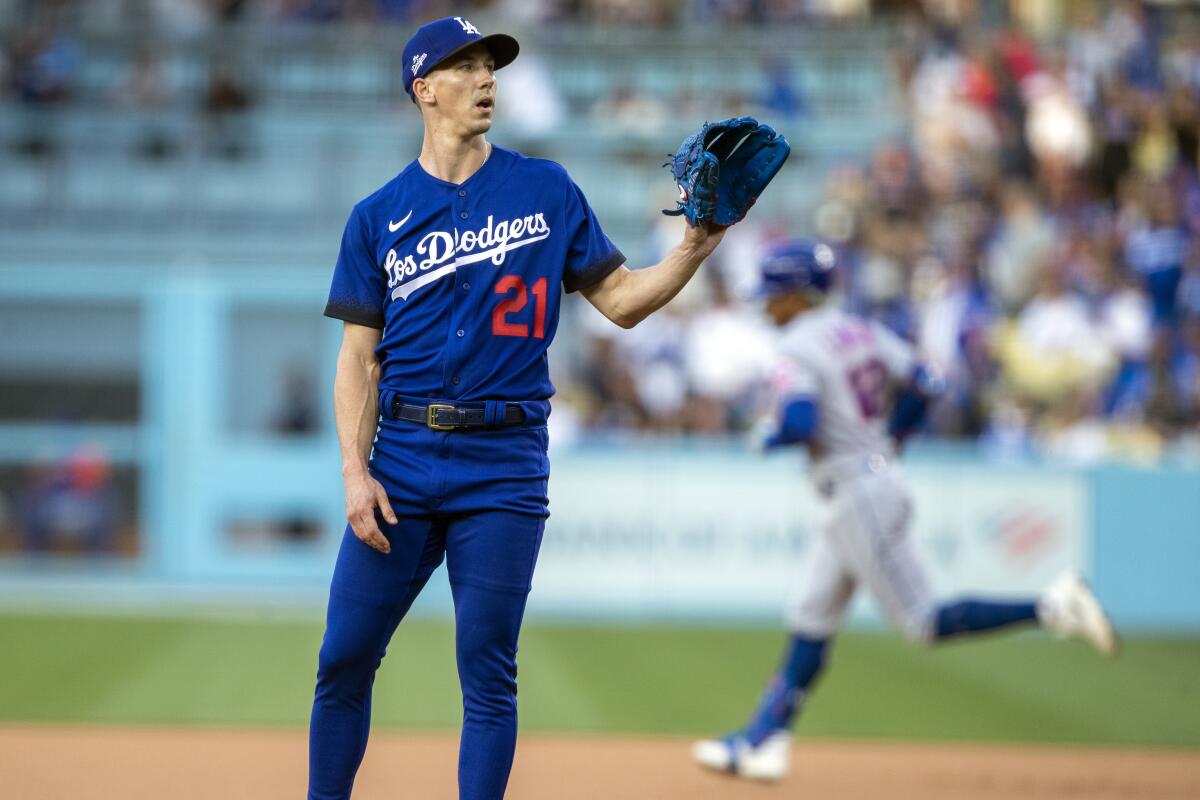 Dodgers pitcher Walker Buehler waits for the next ball as New York Mets' Francisco Lindor rounds the bases.