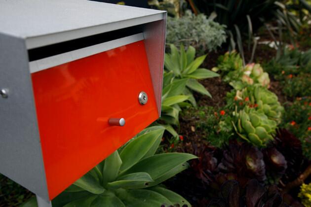 The color of the garden gate and front ground cover is echoed in the mailbox from Modern Mailboxes.