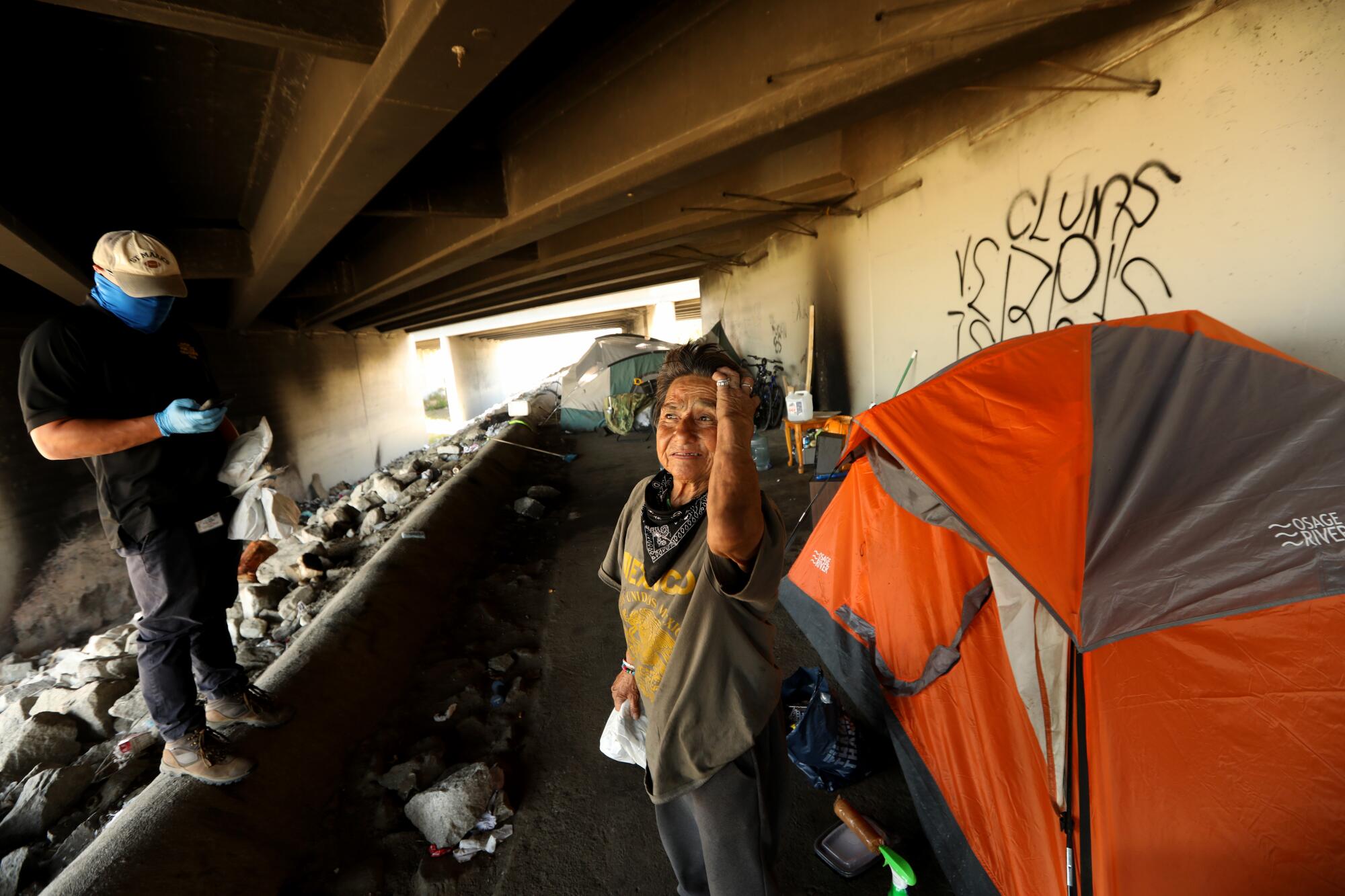 Ramona Gutierrez stands near her encampment under the 605 Freeway.
