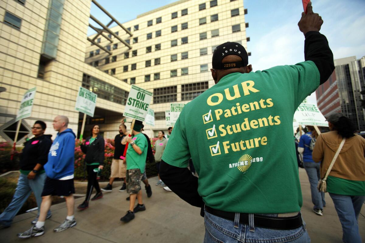 Alfred Rogers, right, a cardiovascular technologist, joins strikers Wednesday morning in front of the Ronald Reagan UCLA Medical Center. The one-day strike affected UC facilities throughout the state.