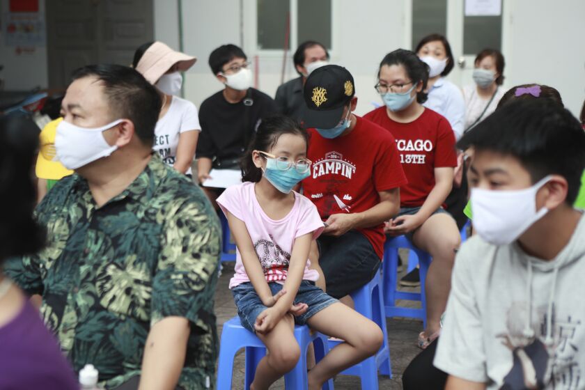 People wait in line to be tested for COVID-19 in Hanoi, Vietnam, Friday, July 31, 2020. Vietnam reported on Friday the country's first ever death of a person with the coronavirus as it struggles with a renewed outbreak after 99 days without any cases. (AP Photo/Hau Dinh)
