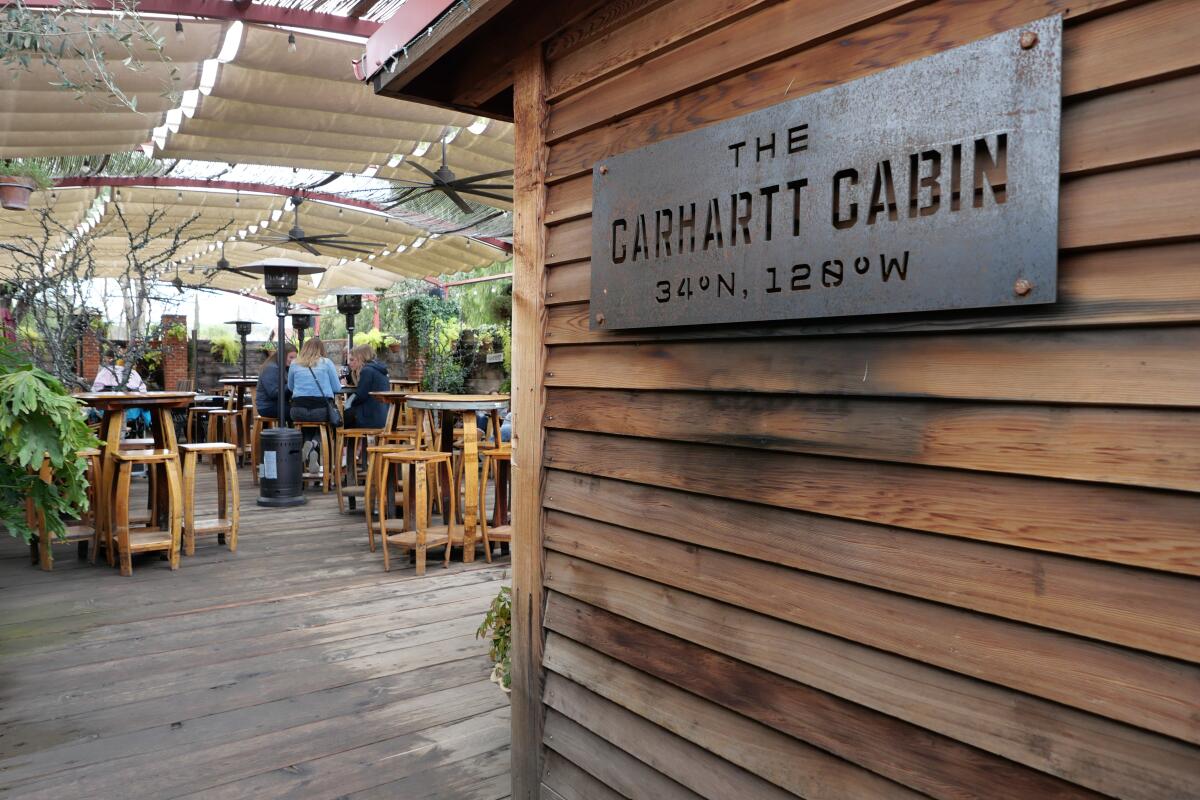A sign that reads "The Carhartt Wine Cabin" at the entry to a covered tasting area.