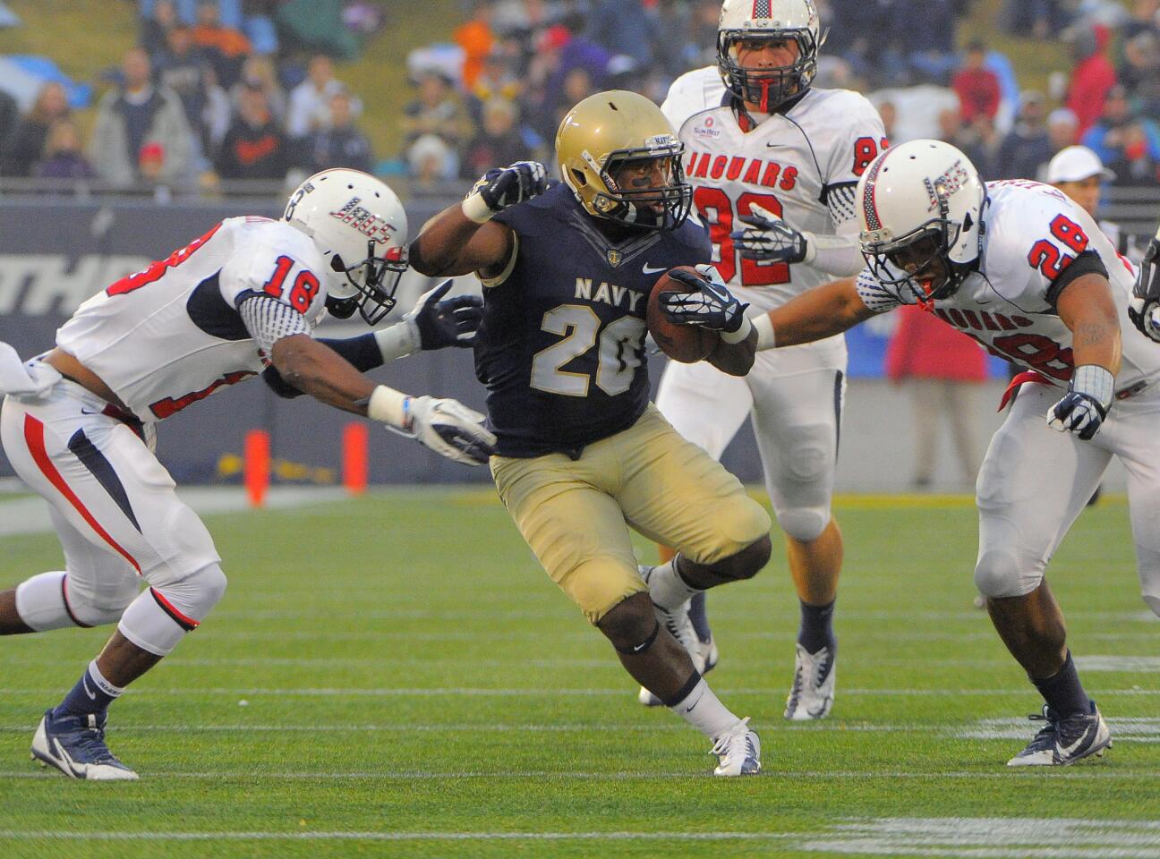 South Alabama's Terrell Brigham (18) and Enrique Williams (28) close in on Navy's Darius Staten (20).