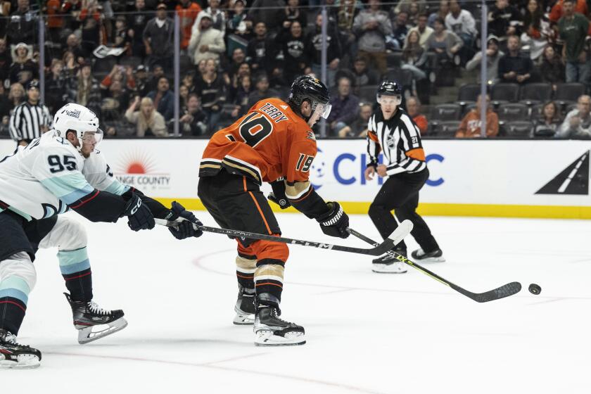 Anaheim Ducks right wing Troy Terry (19) shoots for a game-winning goal past Seattle Kraken left wing Andre Burakovsky (95) during overtime in an NHL hockey game in Anaheim, Calif., Wednesday, Oct. 12, 2022. The Ducks won 5-4. (AP Photo/Kyusung Gong)