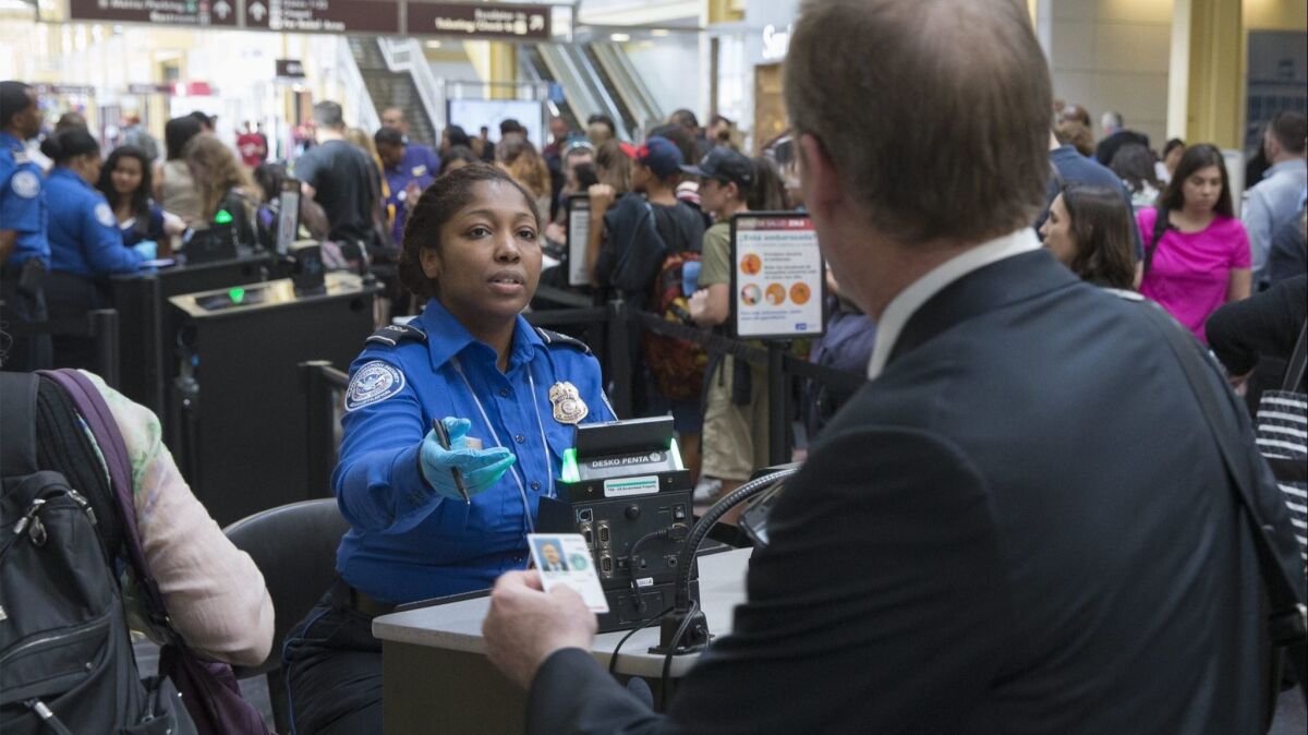 A Transportation Security Administration officer inspects a traveler's documents at Ronald Reagan Washington National Airport in Arlington, Va., in June 2016.