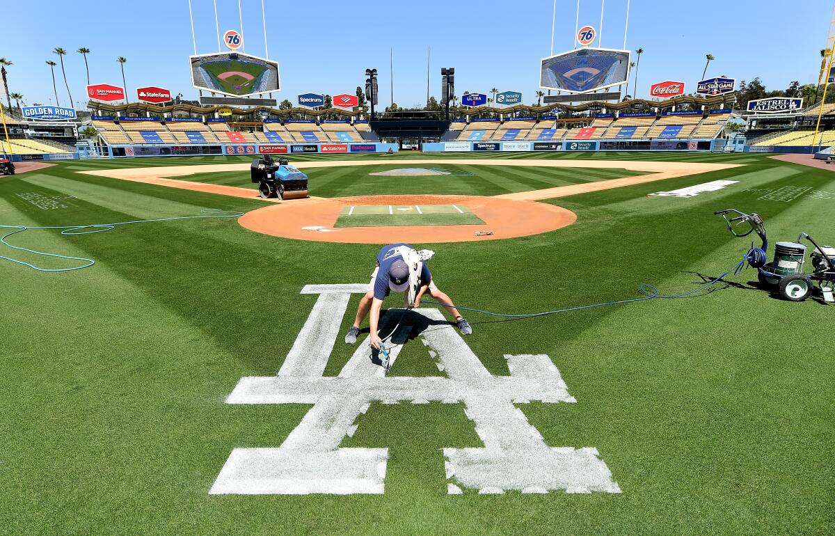 Dodgers ground crew member Justin Patenaude paints the field in preparation for opening day in April 2021.