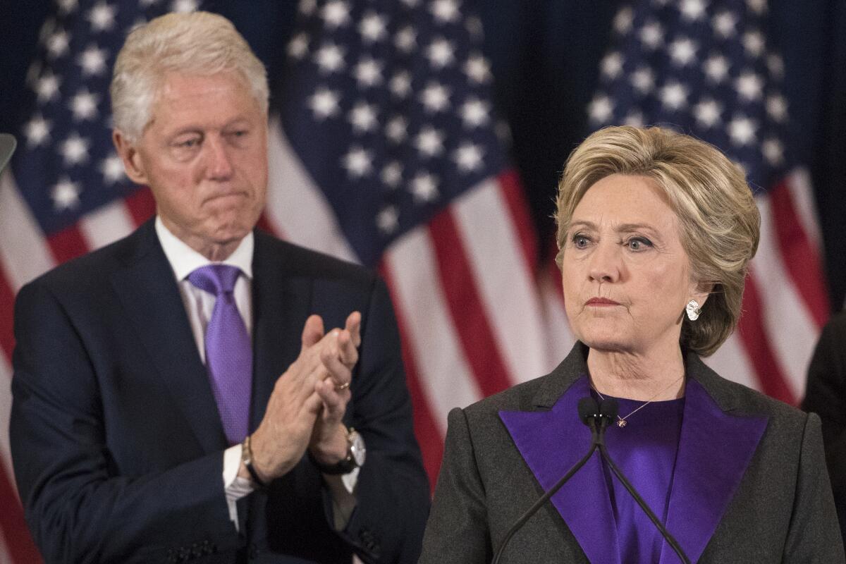 Bill Clinton and Hillary Clinton with grim expressions