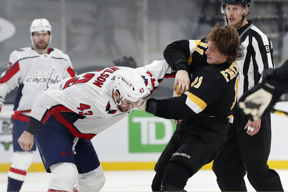 Boston Bruins' Trent Frederic (11) and Washington Capitals' Tom Wilson (43) fight during the third period of an NHL hockey game, Friday, March 5, 2021, in Boston. (AP Photo/Michael Dwyer)