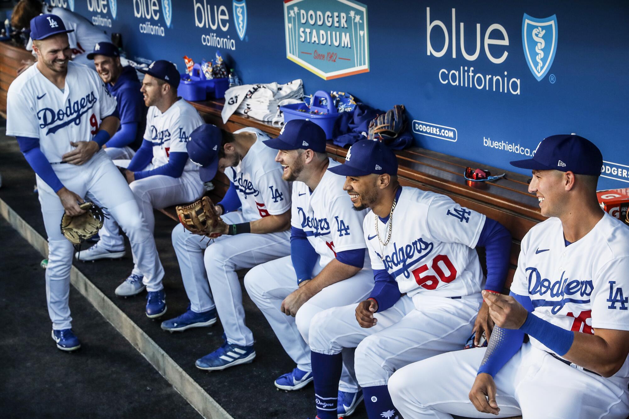Dodgers teammates share a laugh in the dugout before taking on the Colorado Rockies at Dodger Stadium Tuesday.
