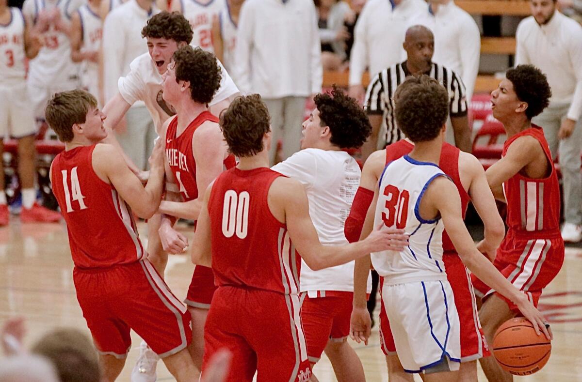 Mater Dei players rush the court to hug Luke Barnett after his winning three-pointer at the buzzer against Los Alamitos.