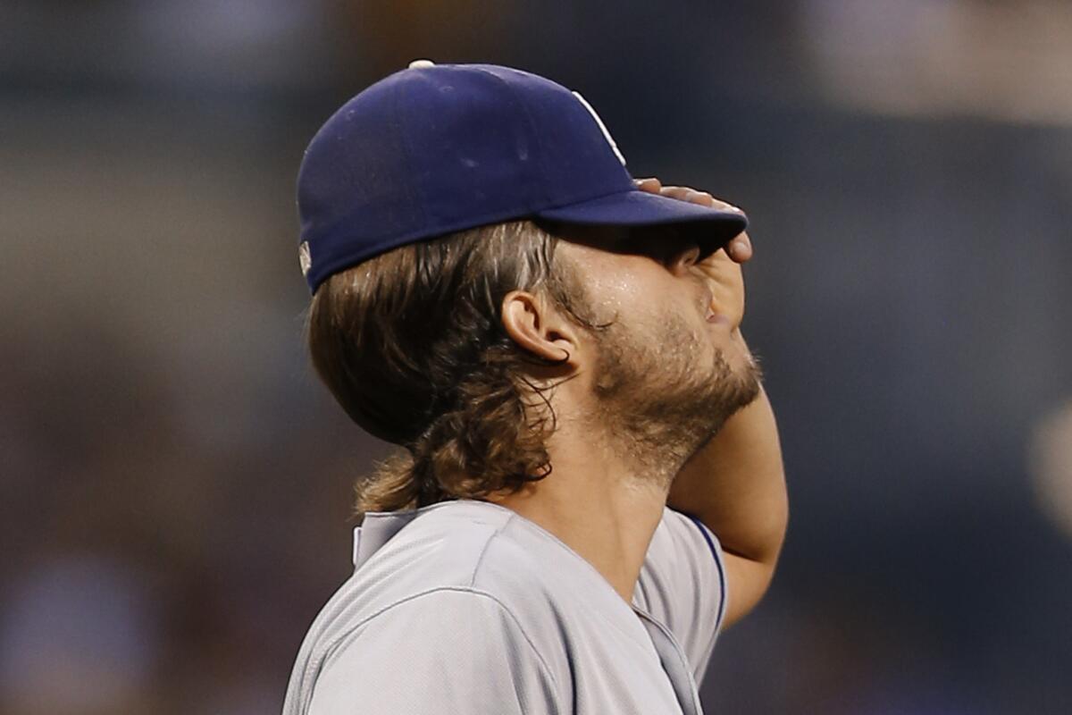 Dodgers starting pitcher Clayton Kershaw pulls down his cap after walking a Pirates batter with the bases loaded in the fourth inning.