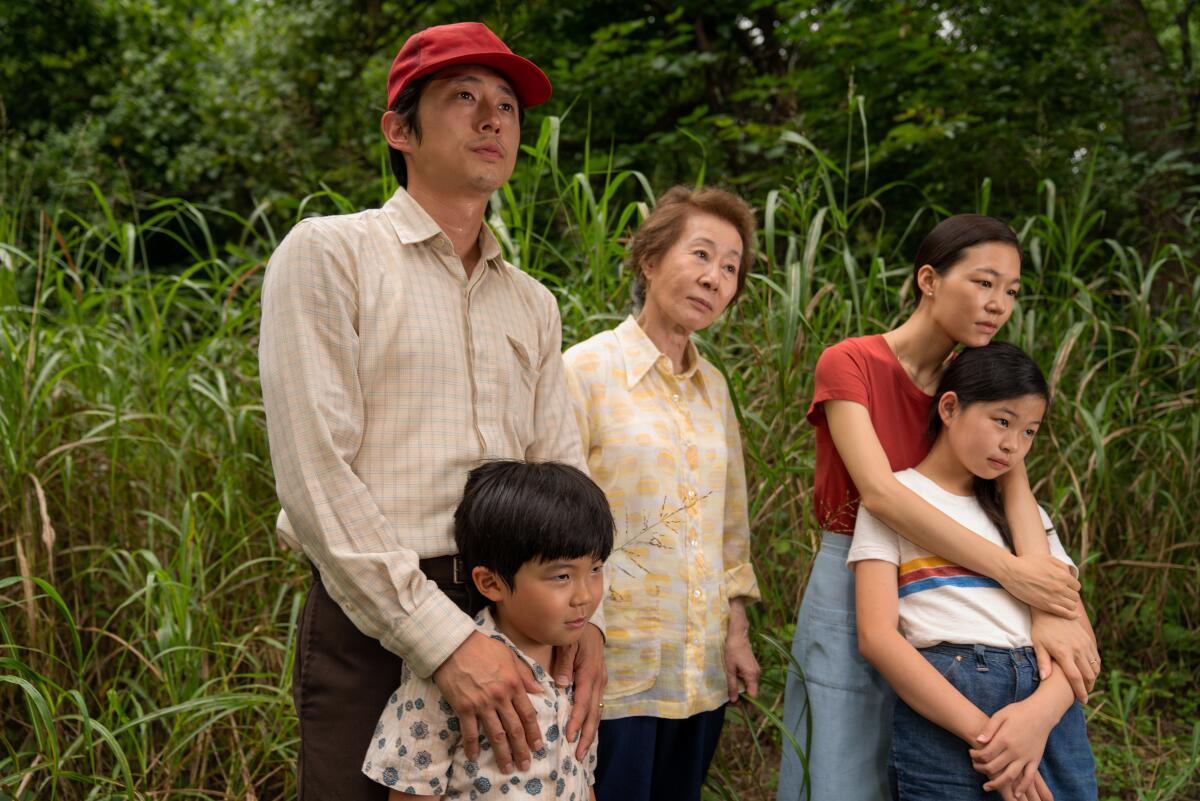 The “Minari” family stands in a grassy field.