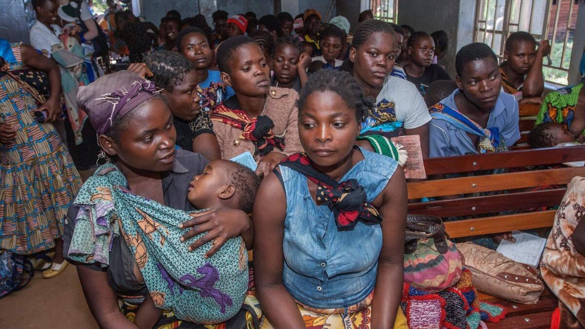 Mothers wait for their children to receive treatment at a malaria vaccine pilot program April 23 at Mitundu Community hospital in Malawi.