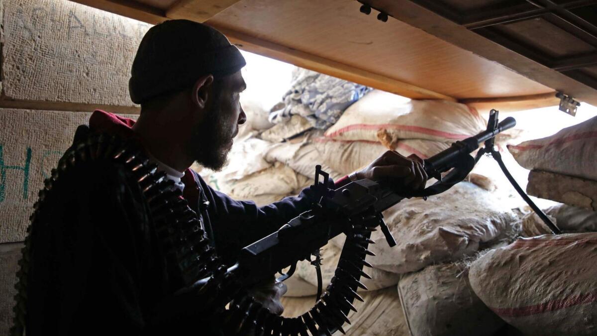 A Syrian rebel fighter from the National Liberation Front holds a position near Idlib province on Monday. Airstrikes hit the edges of Syria's last major rebel stronghold west of Aleppo the day before, following a suspected chemical attack that Syria and Russia blamed on rebels.