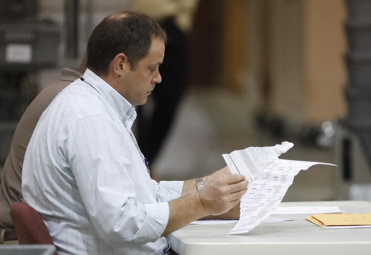 Employees look through damaged ballots during a recount Thursday in West Palm Beach, Fla.