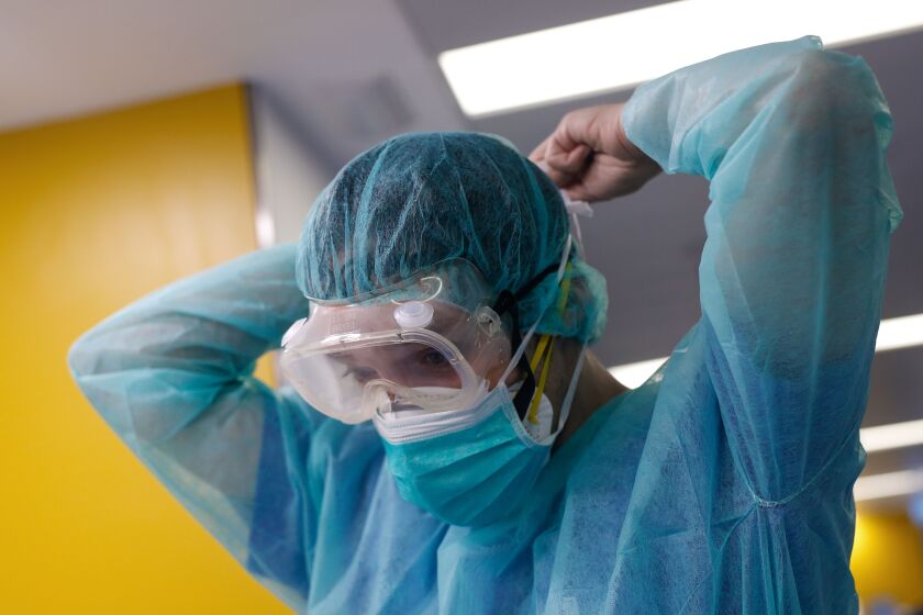 A healthcare worker wearing a protective suit gets ready to attend to a COVID-19 coronavirus patient at the Intensive Unit Care (ICU) of the Vall d'Hebron Hospital in Barcelona on April 6, 2020. - Spain declared a fourth consecutive drop in the number of coronavirus-related deaths with 637 over the past 24 hours, the lowest number in nearly two weeks. (Photo by PAU BARRENA / AFP) (Photo by PAU BARRENA/AFP via Getty Images)