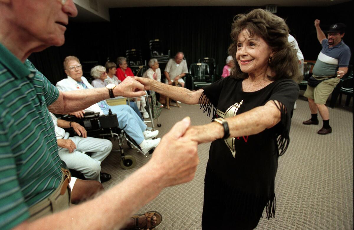 July 27, 1999: Caren Marsh-Doll dances with a client of the Stroke Activity Center in Palm Springs where she volunteers once a month doing dance therapy. She was one of 13 survivors of the 1949 Standard Airlines crash.