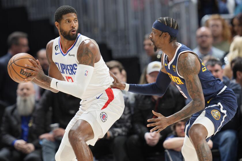 Los Angeles Clippers forward Paul George, left, looks to pass the ball as Denver Nuggets guard Kentavious Caldwell-Pope.