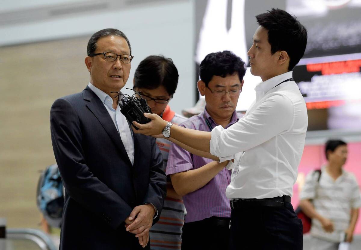 Asiana Airlines President Yoon Young-doo, left, answers reporters' questions at Incheon International Airport before heading to San Francisco.