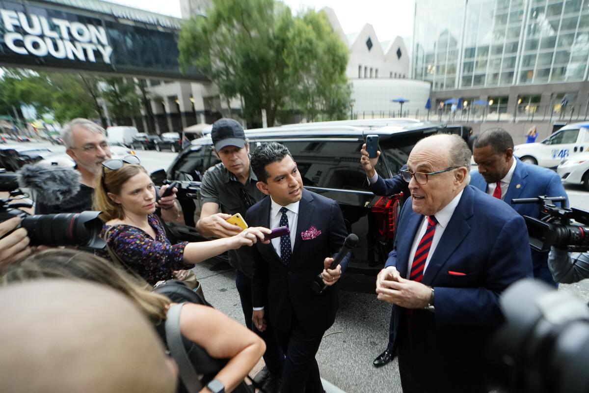 Rudolph W. Giuliani surrounded by journalists at Atlanta courthouse