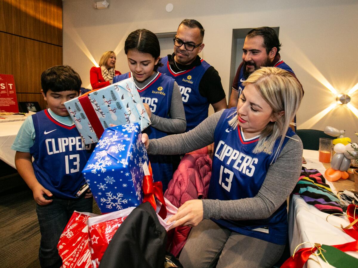 La familia Ríos abre regalos que fueron donados por la estrella de LA Clippers, Paul George.