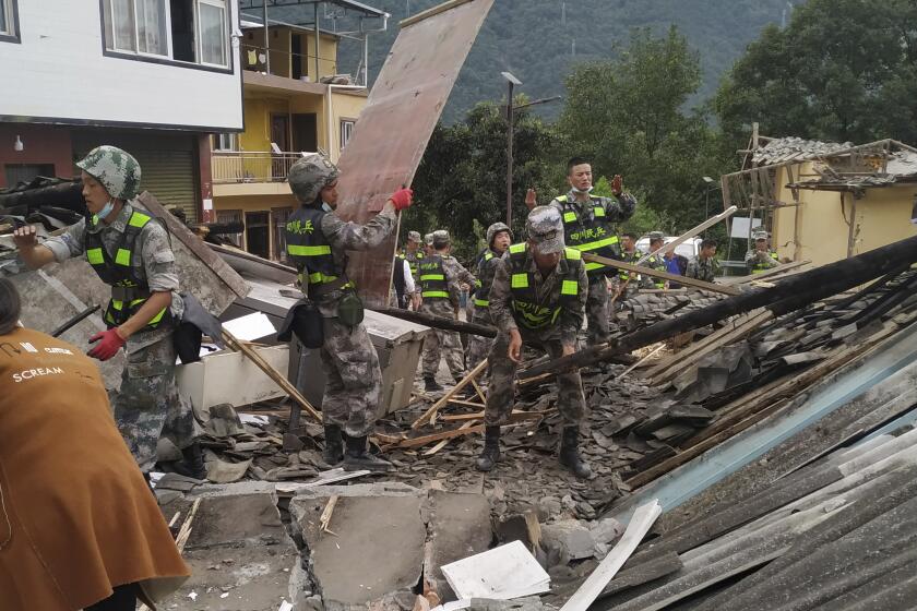 In this photo released by Xinhua News Agency, soldiers clear debris to search for survivors at an earthquake hit Moxi Town of Luding County, southwest China's Sichuan Province Tuesday, Sept. 6, 2022. Authorities in southwestern China's Chengdu have maintained strict COVID-19 lockdown measures on the city of 21 million despite a major earthquake that killed more than dozens people in outlying areas. (Ran Peizong/Xinhua via AP)