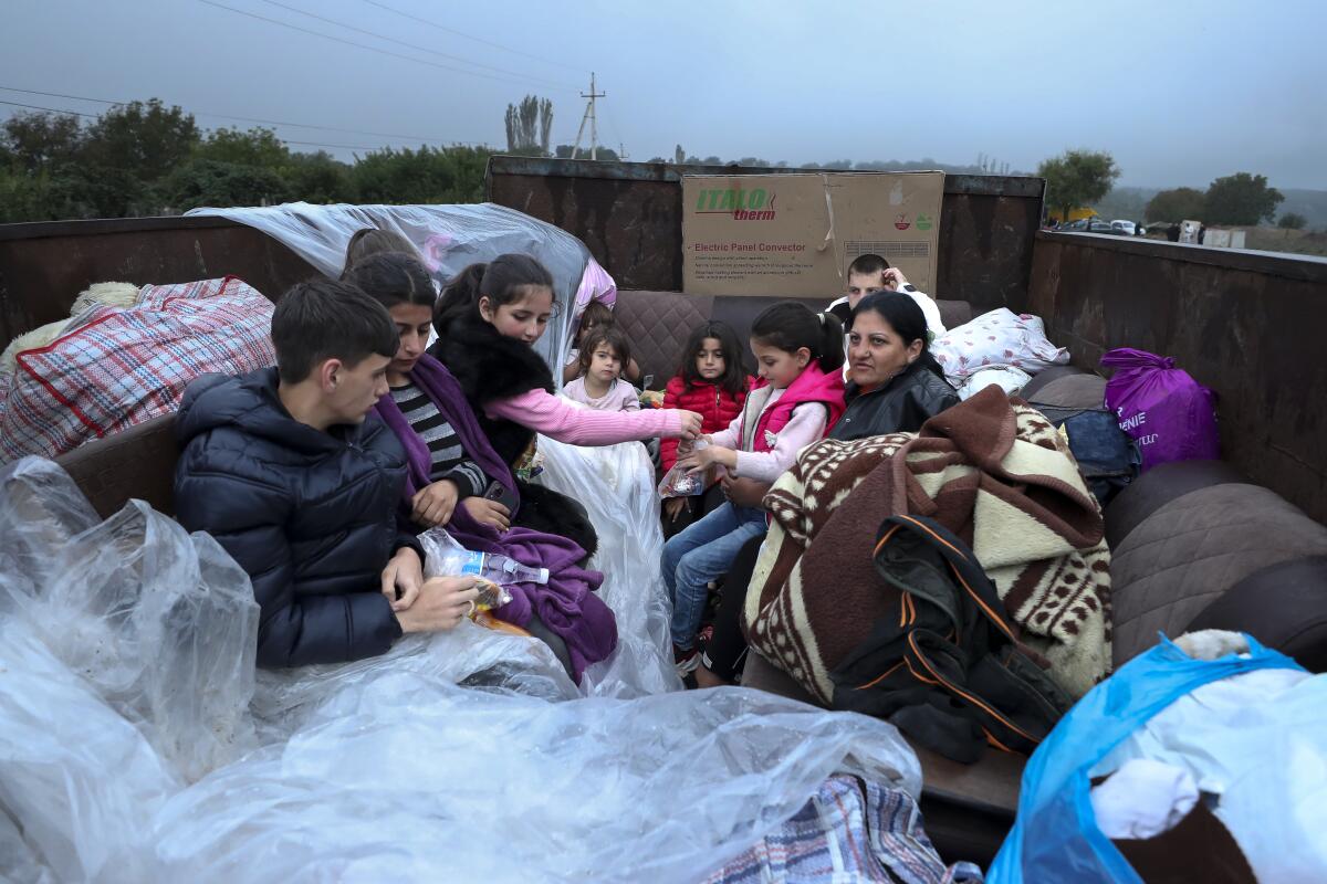 Ethnic Armenians from Nagorno-Karabakh sit in a truck on their way to Armenia on Monday.