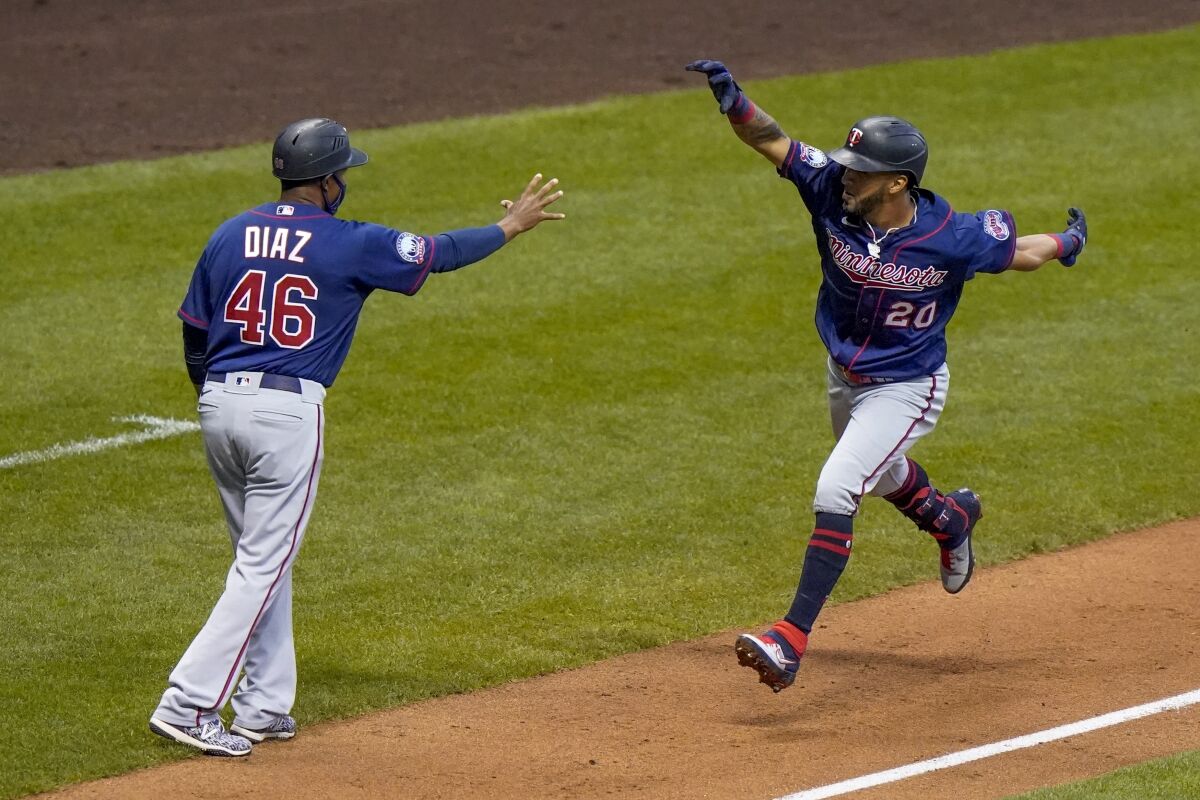 Minnesota Twins' Eddie Rosario celebrates his grand slam with third base coach Tony Diaz during the third inning of a baseball game against the Milwaukee Brewers Monday, Aug. 10, 2020, in Milwaukee. (AP Photo/Morry Gash)