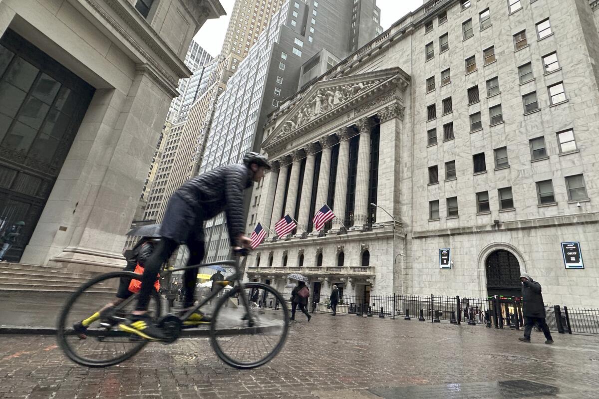 A bicyclist passes the New York Stock Exchange building.