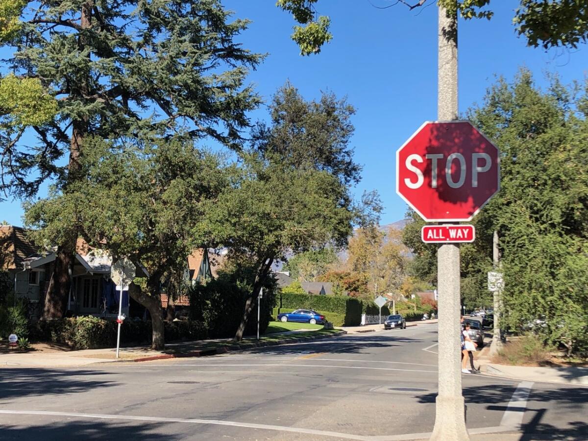 A stop sign at a four-way intersection in a residential neighborhood
